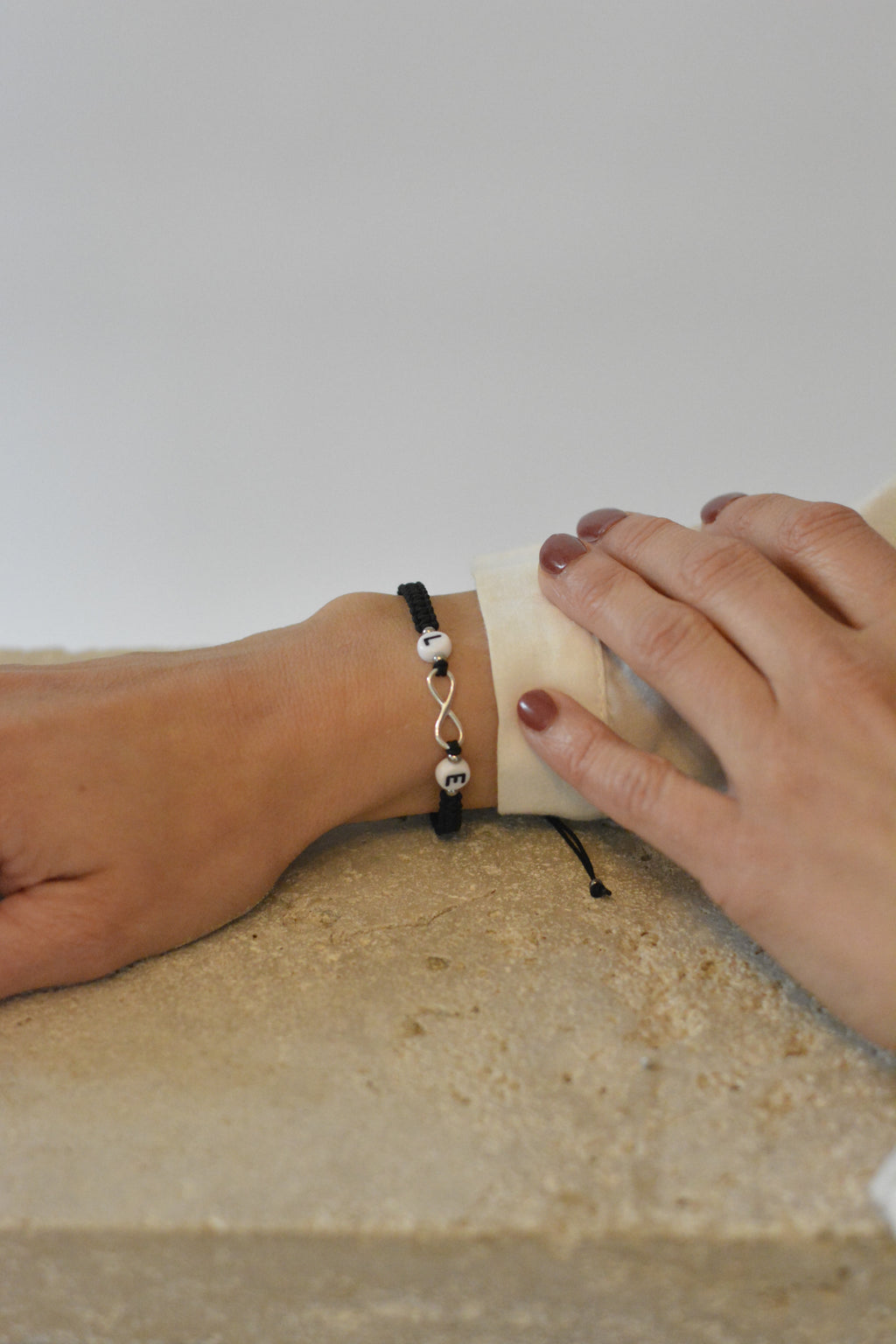 personalisiertes Makrameearmband mit Infinity Zeichen und Initialienperlen